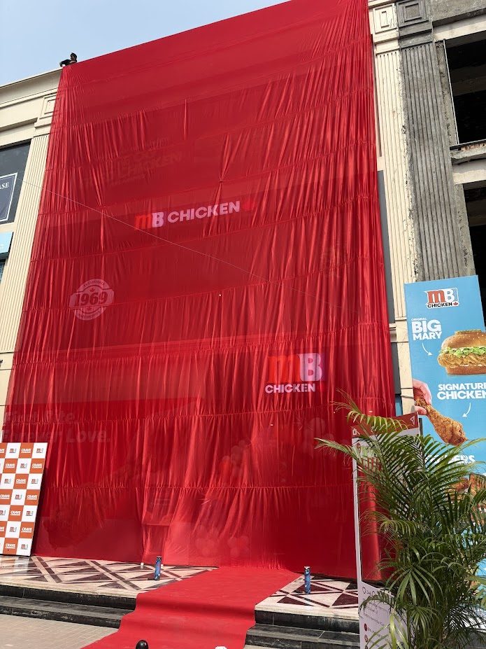 MB Chicken grand opening red drape reveal